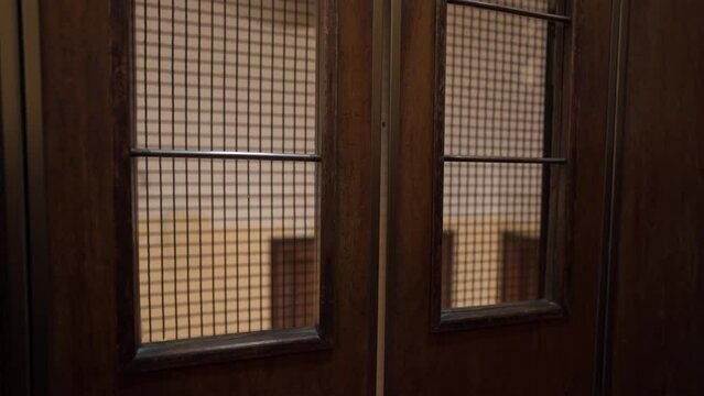 Inside a fast-moving vintage elevator that is going up.