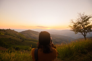 Woman travel tourist alone morning freedom and happiness. with sunset view of nature cliff mountain.