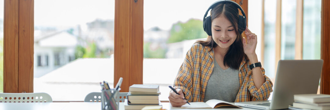 Self learning concept. Young woman student wear headphone listening audiobook technology education