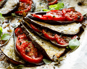 Stuffed eggplant with tomatoes and cheese with addition aromatic herbs, close-up view