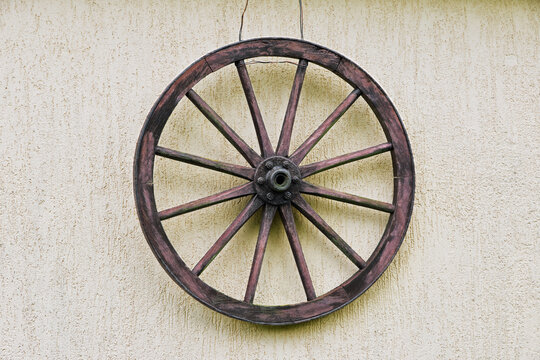 vintage vehicle wheel made of wood with iron rim and bearing hanging on the wall