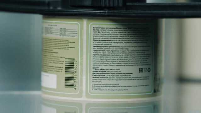 Almaty, Kazakhstan - January 8 2023: Labeling machine in industrial factory. Conveyor production line. Technology, manufacturing, food packaging, advertising concept