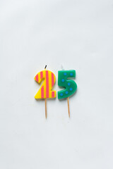 top view of number candles, number 25 candle on a white background, birthday candles on white...
