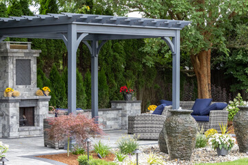 Landscape architecture featuring pergola and stone fireplace with stone urn water fountains - obrazy, fototapety, plakaty