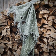 Alter Holzstapel über dem ein Fetzen einer zerrissenen Plane hängt