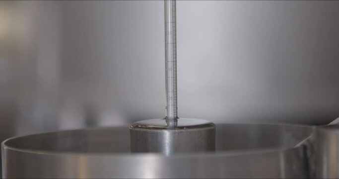 Close-up shot of a densimeter in the tequila.