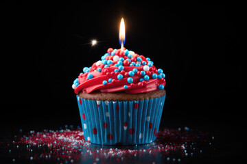Delightful birthday cupcake adorned with a single lit candle, set against a dark backdrop. Perfect for celebrations, joy, and special occasions.