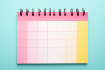 A lively image of a pink and yellow planner set against a vibrant bright blue background. Perfect for organization, creativity, and planning-themed visuals.