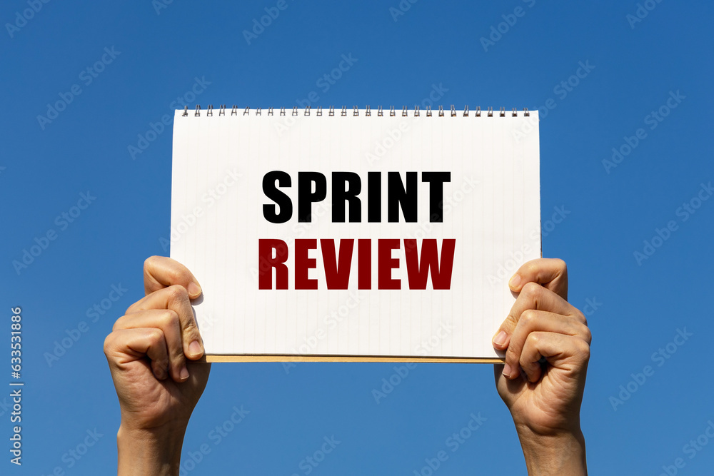 Poster sprint review text on notebook paper held by 2 hands with isolated blue sky background. this message