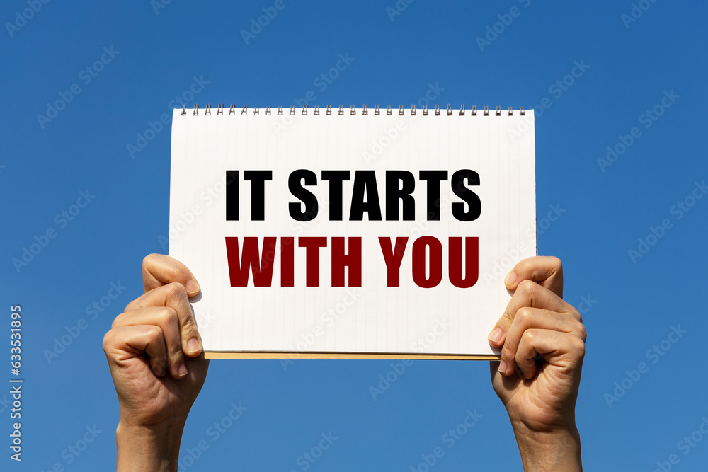 Poster it starts with you text on notebook paper held by 2 hands with isolated blue sky background. this me