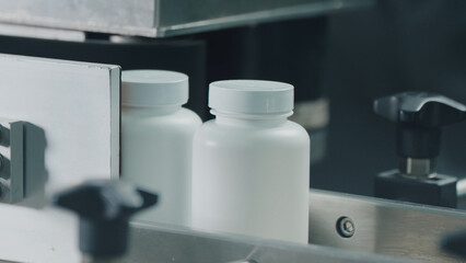 Products in tubes move along the production automatic conveyor belt. Production of dietary supplements. Close up, DOF