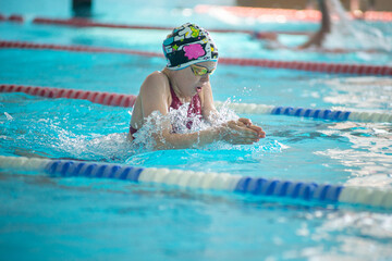 Swimmer child swims breaststroke swimming style in the pool - 633533079