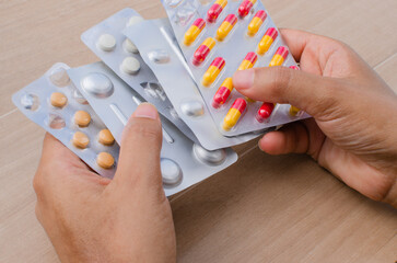 Closeup of hand holding a variety of medicine in pills and tablets, vitality and health. Perfect for illustrating treatments, medical care, pharmacy and wellness.