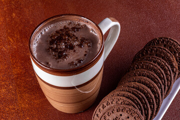 Cup of milk with cocoa and chocolate biscuits.