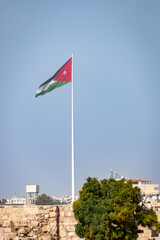 Huge flag of Jordan waving in the capital city of Amman