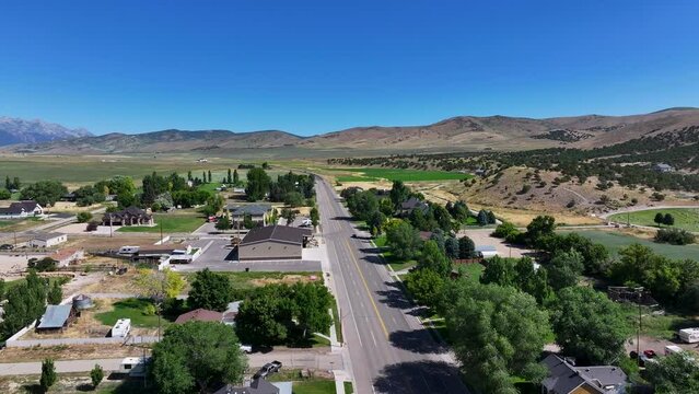Rural mountain town main street Utah pull fast. Farming community agricultural economy. Spring summer weather mountain valley green agriculture field. Homes, barns and buildings.