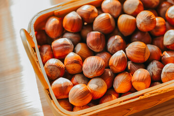  Hazelnuts in a basket on a wooden table. Fresh harvest of hazelnuts. Farmed organic ripe hazelnuts. 