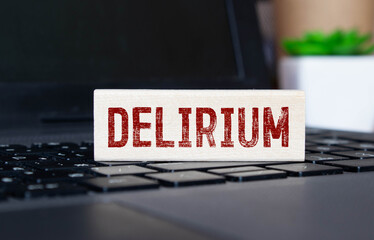 word delirium made of wooden letters on a gray table on a green background