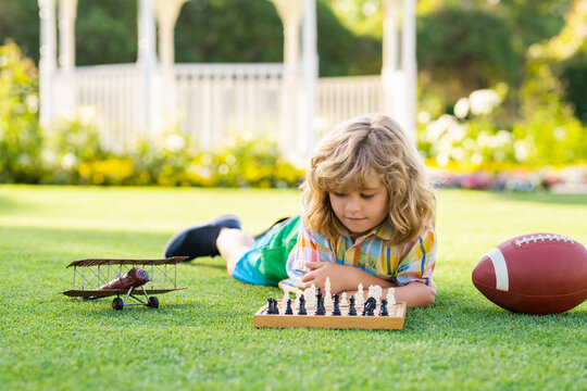 Smart kid playing chess. Clever child thinking about chess.