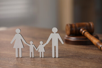 Family law. Figure of parents with children and gavel on wooden table, space for text