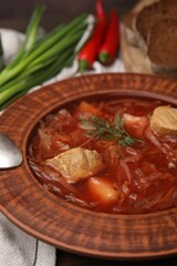 Bowl of delicious borscht on table, closeup.