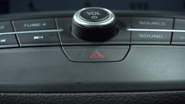 Turning On Emergency Flasher of the Car. Pressing Car Hazard Emergency Lights Button Close Up