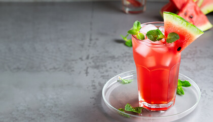 Iced fruit tea or cold watermelon drink in clear glass with mint leaf. Refreshing summer drink....