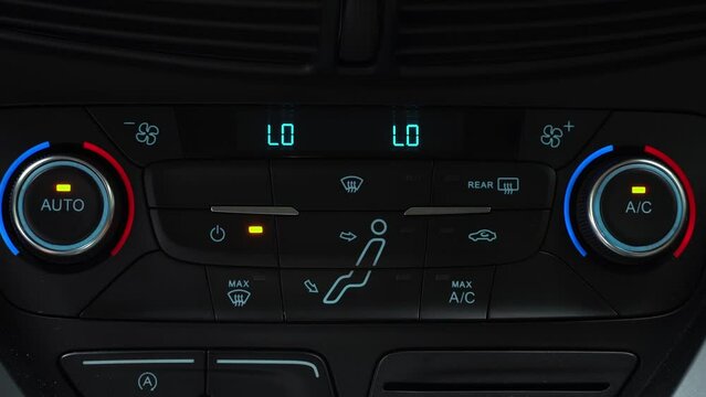 Finger presses button for turning off maximum airflow on the multimedia panel of car, two-phase climate control in the car