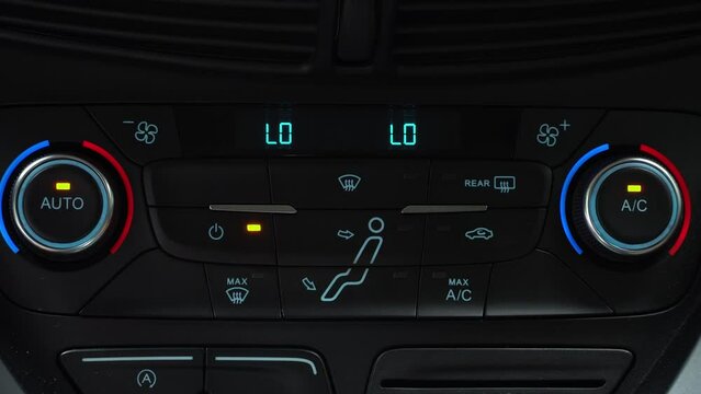 Finger presses button for turning off maximum ac airflow on the multimedia panel of car, two-phase climate control in the car