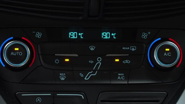 Finger presses button for turn on air recirculation mode in passenger compartment, two-phase climate control in the car