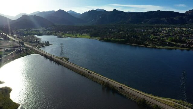 Cars ride over the highway cut right into Lake Estes in Colorado