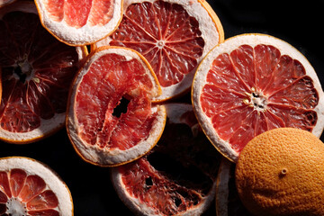 Top view of dried grapefruit on black background