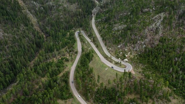 Cars navigate a switchback on a windy road in the Black Hills of SD