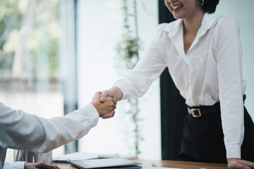 Successful young business woman having a hand shake with her client after the contract was done successfully.