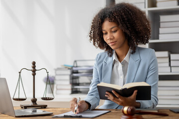American woman is legal litigation attorney, Female lawyer is in a law firm drafting contracts and reading client case details to study and find a solution to win the case. Lawyer and justice concept.