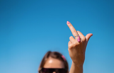 Middle finger gesture. Heart shaped ring on female middle finger. Fuck you concept.