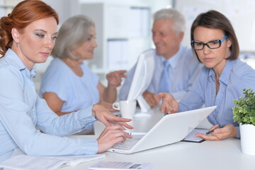 happy businesswomen and businessman working in office