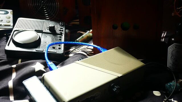 Modern collection of paranormal ghost box EVP communication devices panning across shadowy boxes