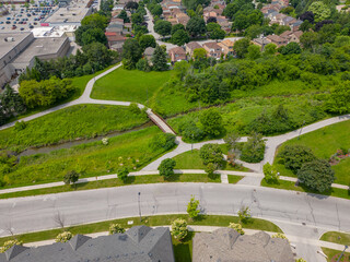 Experience a park in Ajax, Ontario, from an awe-inspiring drone view, which reveals the lush green spaces that make it a prized location for real estate. Winding paths, inviting benches, 