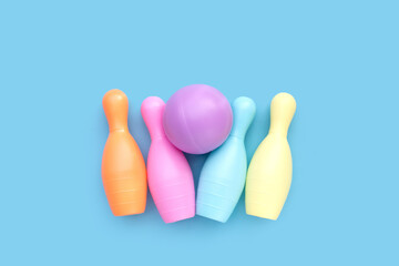 Colorful plastic bowling toy on blue background.