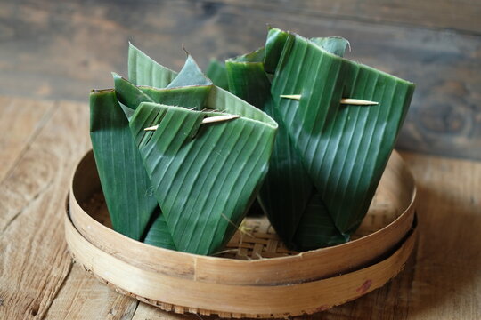 two banana leaf wrapper on a woven bamboo container. in some Asian countries banana leaves are used to wrap food. bungkusan daun pisang.