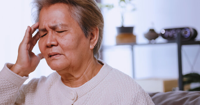 Asian old woman with migraine headache. Elderly woman suffering from a headache.