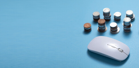 Computer mouse and coins on the blue background.