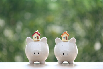 Model house on piggy bank with stack of coins money on nature green background,Business investment and real estate concept