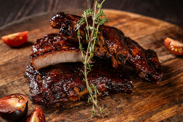 American cuisine, glazed fried ribs in honey and soy sauce lie on a wooden board. background image...