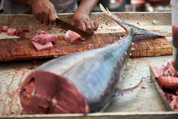 A resident of Kerala cuts freshly caught tuna on a chopping board