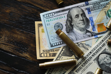 Illegal selling, criminal money concept, US dollars and bullet for a gun, cartridges on a background
