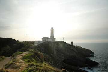 Fototapeta na wymiar Lighthouse on top of a cliff by the sea. Santander, Cantabria, Spain