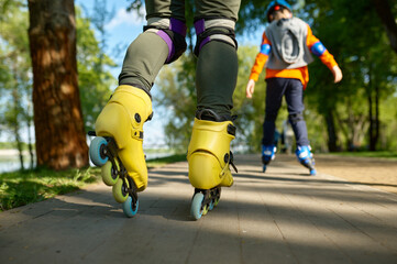 Fototapeta na wymiar Active people on roller skates in park road closeup view
