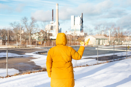 holding bananas, wearing a coat, in winter